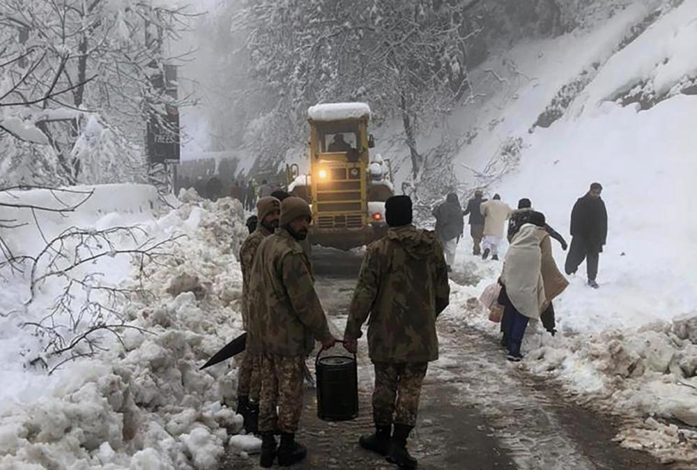 In this photo provided by the Inter Services Public Relations, army members take part in a rescue operation in a heavy snowfall-hit area in Murree, some 28 miles (45 kilometers) north of the capital of Islamabad, Pakistan, Saturday, Jan. 8, 2022. Temperatures fell to minus 8 degrees Celsius (17.6 Fahrenheit) amid heavy snowfall at Pakistan's mountain resort town of Murree overnight, killing multiple people who were stuck in their vehicles, officials said Saturday. (Inter Services Public Relations via AP)