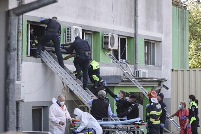 Rescatistas ayudan a sacar a un paciente en una camilla después de un incendio en la sección de UCI contra el COVID-19 del Hospital de Enfermedades Infecciosas en Constanza, Rumania, el viernes 1 de octubre de 2021. (AP Foto/Costin Dinca)