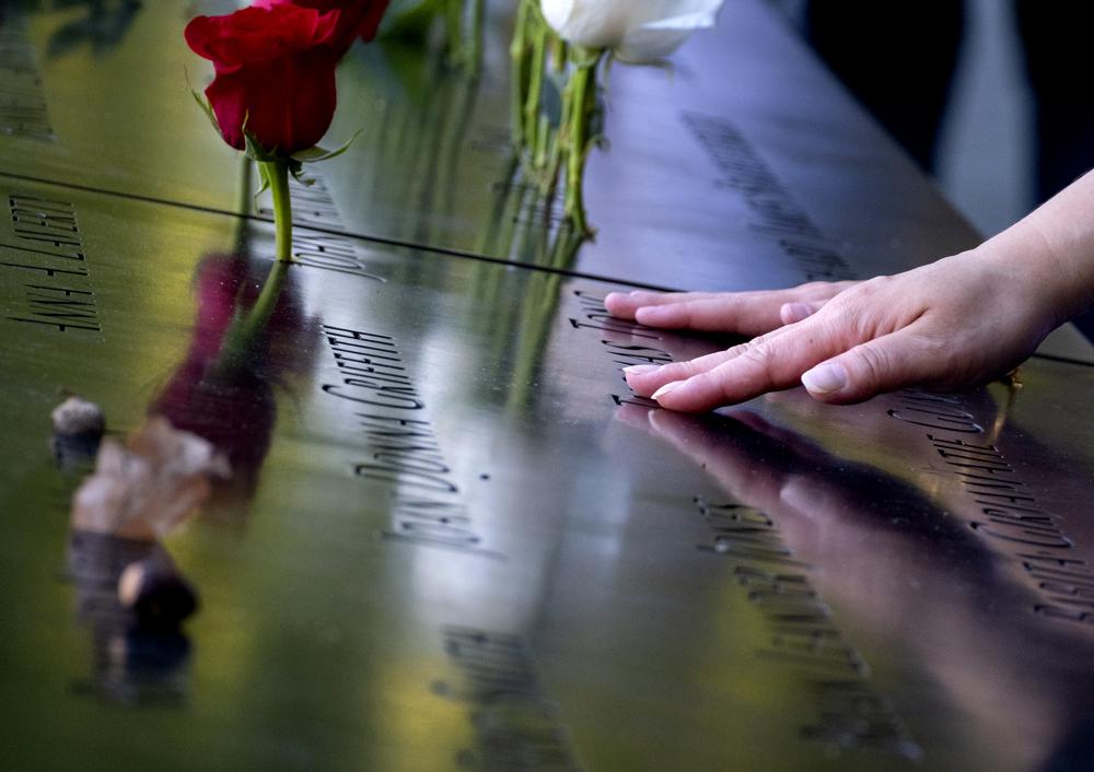 Hands touch the names of people who were killed during the attacks on the World Trade Center on Sept. 11, 2001, as families gather at the National September 11 Memorial in New York on the 20th anniversary of the attacks, Saturday, Sept. 11, 2021. (Craig Ruttle/Newsday via AP, Pool)