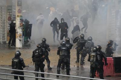 Estudiantes universitarios y policías chocan durante enfrentamientos después de una manifestación que conmemoraba el paro nacional del año pasado contra una reforma fiscal propuesta por el gobierno que se tornó violenta, en Bogotá, Colombia, el jueves 28 de abril de 2022. (AP Foto/Fernando Vergara)