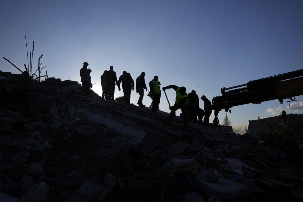 Rescue teams search for people in the rubble of destroyed buildings in Antakya, southern Turkey, Wednesday, Feb. 8, 2023. With the hope of finding survivors fading, stretched rescue teams in Turkey and Syria searched Wednesday for signs of life in the rubble of thousands of buildings toppled by a catastrophic earthquake. (AP Photo/Khalil Hamra)