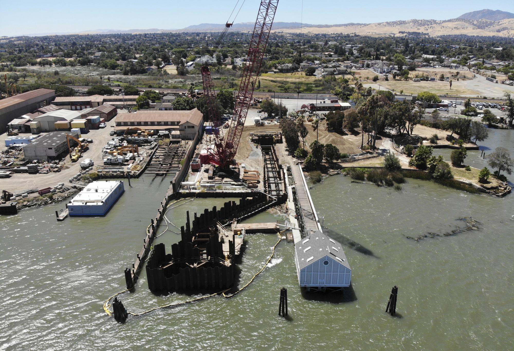 Construction is underway for intake pipes to draw water from the San Joaquin River for a water desalination plant in Antioch Calif., Thursday, July 21, 2022. The plant will be the state's first inland desalination plant for brackish surface water, said John Samuelson, the city’s director of public works. (AP Photo/Terry Chea)