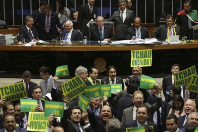 Legisladores a favor de hacerle un juicio político a la presidenta brasileña Dilma Rousseff sostienen carteles que dicen "chau querida" durante una sesión de la cámara baja en Brasilia el 16 de abril del 2016. Para muchos, esa fue una manifestación de machismo. (AP Photo/Eraldo Peres, File)