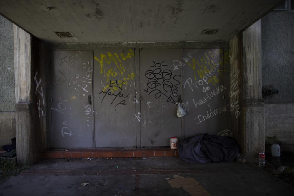 Un indigente duerme frente al aula Aula Magna de la Universidad Central de Venezuela (UCV) en Caracas, Venezuela, el miércoles 7 de julio de 2021. (AP Foto/Ariana Cubillos)