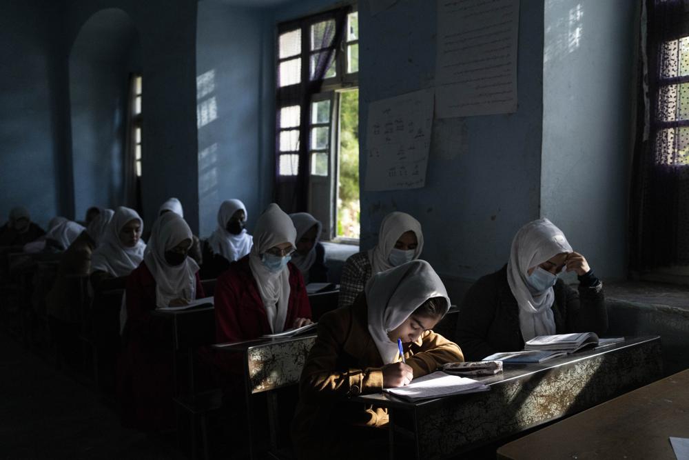 FILE - Afghan girls participate in a lesson at Tajrobawai Girls High School in Herat, Afghanistan on Nov. 25, 2021. In a surprise decision the hardline leadership of Afghanistan's new rulers has decided against opening educational institutions to girls beyond Grade six, a Taliban official said Wednesday, March 23, 2022 on the first day of Afghanistan's new school year. (AP Photo/Petros Giannakouris, File)