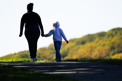 ARCHIVO - Una mujer y un niño caminan por un sendero en el Parque Histórico Nacional Valley Forge en Valley Forge, Pensilvania, el 1 de noviembre de 2021. Los demócratas y republicanos del Senado quieren mostrar señales del año electoral de que están ayudando a las familias que luchan con el aumento de los costos y la pandemia de dos años. Pero las partes difieren sobre cómo hacerlo. (AP Photo/Matt Rourke, Archivo)