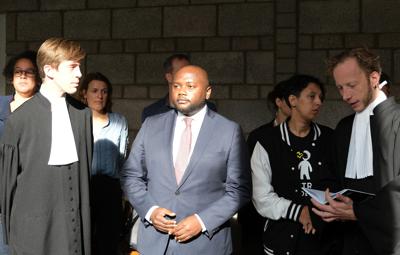 Mpanzu Bamenga (centro), su equipo legal y activistas de derechos humanos durante una audiencia en el tribunal de distrito de La Haya, Holanda, el miércoles 22 de septiembre de 2021, después de perder un caso de etiquetación racial. (AP Foto/Mike Corder)