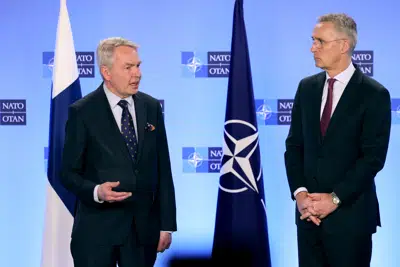 NATO Secretary General Jens Stoltenberg, right, speaks with Finland's Foreign Minister Pekka Haavisto prior to a meeting in Brussels on Monday, March 20, 2023. European Union foreign ministers on Monday will discuss the situation in Ukraine and Tunisia. (AP Photo/Olivier Matthys)