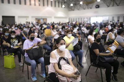 ARCHIVO - Trabajadores de la educación esperan para vacunarse contra el COVID-19 en el World Trade Center en Boca del Río, estado de Veracruz, México, el 20 de abril de 2021. Las autoridades de salud de México anunciaron el martes 16 de noviembre de 2021 que vacunarán contra el coronavirus a los jóvenes de entre 15 y 17 años luego de avanzar en la inmunización de buena parte de la población adulta.  (AP Foto / Félix Márquez, Archivo)