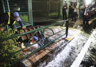 A road is soaked in water following an earthquake, in Tokyo, early Friday, Oct. 8, 2021. A powerful earthquake shook the Tokyo area on Thursday night, halting trains and subways. (Kyodo News via AP)