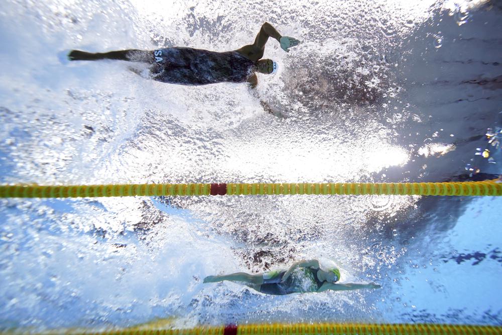 Simone Manuel, top, of the United States, swims alongside Emma Mckeon, of Australia, during heat 10 of the women's 50-meter freestyle at the 2020 Summer Olympics, Friday, July 30, 2021, in Tokyo, Japan. (AP Photo/Jeff Roberson)