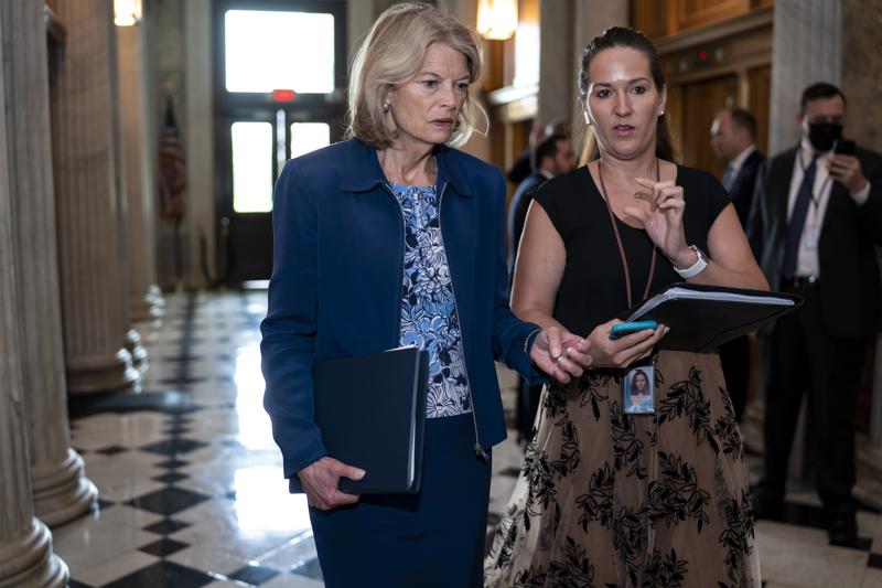 Sen. Lisa Murkowski, R-Alaska, speaks to an aide as senators arrive before a procedural vote on the Women's Health Protection Act to codify the landmark 1973 Roe v. Wade decision that legalized abortion nationwide, at the Capitol in Washington, Wednesday, May 11, 2022. President Joe Biden called on Congress to pass legislation that would guarantee the constitutional right to abortion services after the disclosure of a draft Supreme Court opinion that would overturn Roe v. Wade. (AP Photo/J. Scott Applewhite)