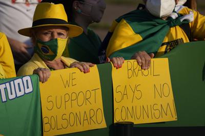 Simpatizantes del presidente brasileño Jair Bolsonaro esperan afuera de la residencia presidencial del Palacio de la Alvorada para el inicio de una ceremonia de izamiento de la bandera en el Día de la Independencia, en Brasilia, Brasil, el martes 7 de septiembre de 2021. (Foto AP/Eraldo Peres)