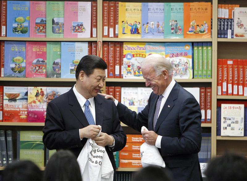 FILE - Chinese Vice President Xi Jinping and Vice President Joe Biden hold T-shirts students gave them at the International Studies Learning Center in South Gate, Calif., Feb. 17, 2012. As President Joe Biden and Xi Jinping prepare to hold their first summit on Monday, Nov. 15, the increasingly fractured U.S.-China relationship has demonstrated that the ability to connect on a personal level has its limits. Biden nonetheless believes there is value in a face-to-face meeting, even a virtual one like the two leaders will hold Monday evening. (AP Photo/Damian Dovarganes, File)