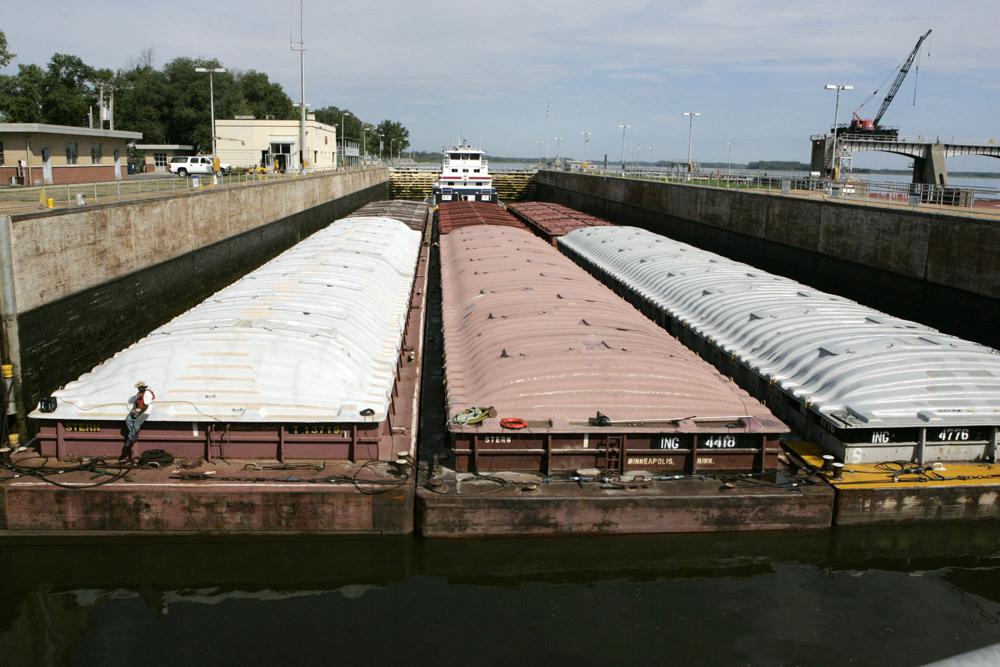 FILE - A towboat and its barges are shown in the channel at lock and dam 25 at Winfield, Mo., on Aug. 19, 2005. The U.S. Army Corps will spend $732 million to expand the congested lock and dam in Missouri. Federal officials said adding a second lock in Winfield will reduce travel time for barges and allow for two-way traffic. Funding for the lock's construction was part of a broader Biden administration announcement Wednesday, Jan. 19, 2022, to provide the Army Corps with $14 billon for infrastructure and environmental restoration projects.  (AP Photo/James A. Finley, File)
