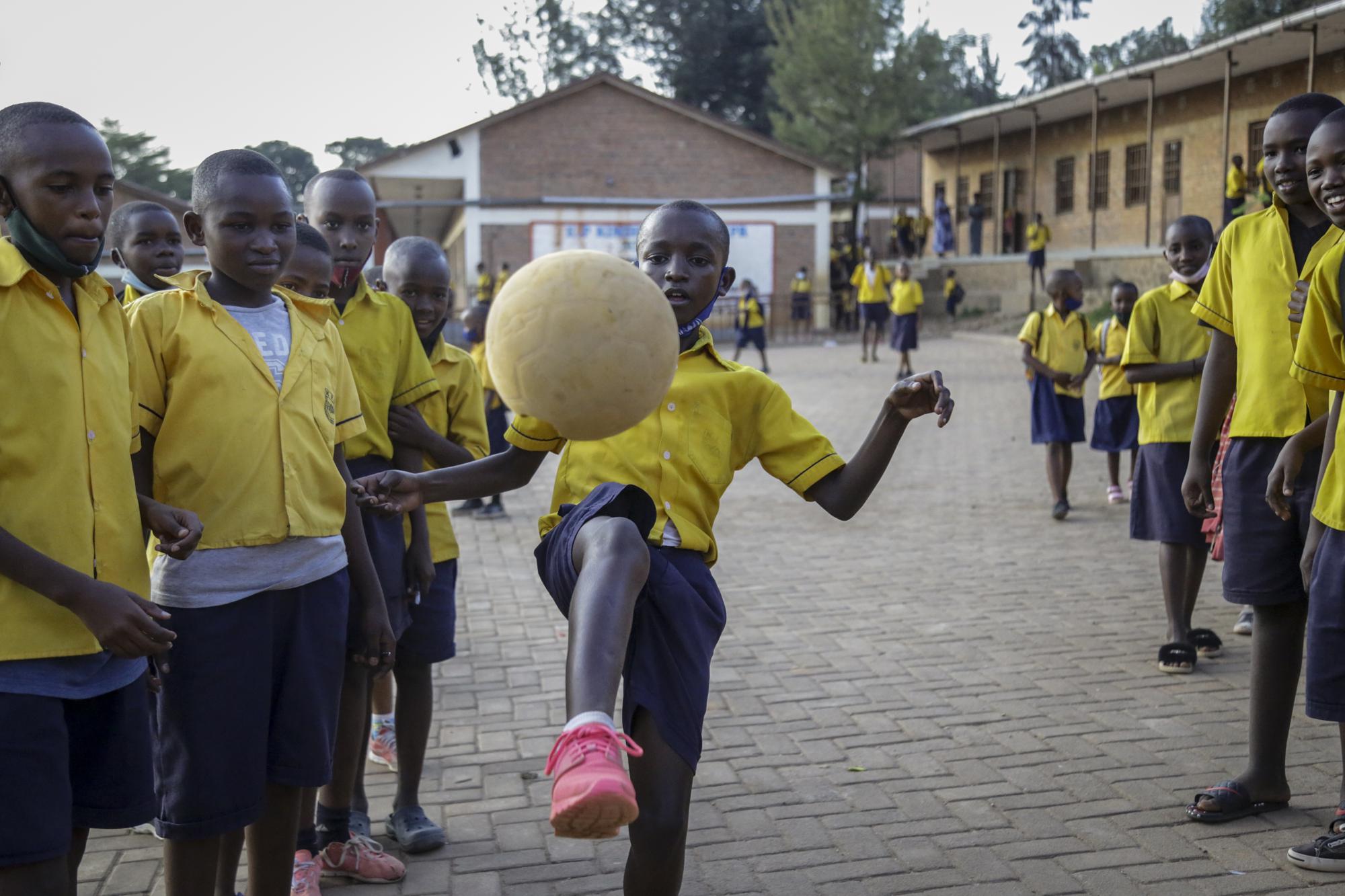 Tresor Ndizihiwe plays soccer with his friends after school at the Kimihurura Primary School in Kigali, Rwanda, on Thursday, June 10, 2021. Tresor says he enjoys playing with others after months at home when he was not allowed to play with his friends or classmates because of the coronavirus pandemic. (AP Photo/Muhizi Olivier)