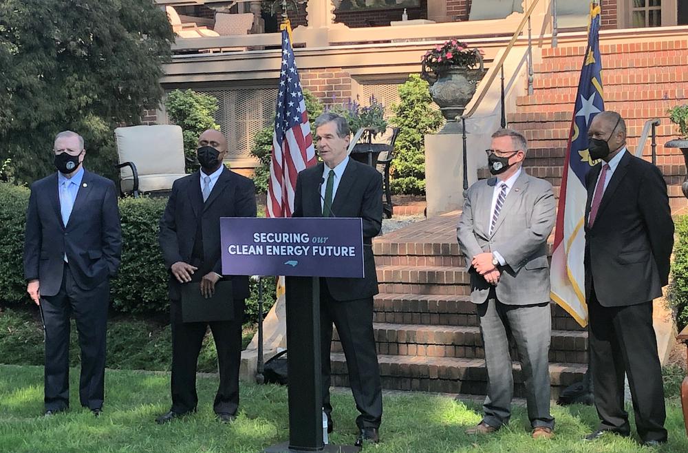 North Carolina Gov. Roy Cooper, center, speaks before he signs into law a major energy bill, listened to, from left to right, by Senate leader Phil Berger, R-Rockingham; House Minority Leader Robert Reives, D-Chatham; House Speaker Tim Moore, R-Cleveland; and Senate Minority Leader Dan Blue, D-Wake, during an Executive Mansion ceremony in Raleigh, N.C. Wednesday, Oct. 13, 2021. (AP Photo/Gary D. Robertson)
