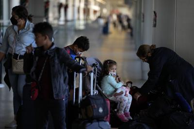 Una familia que regresa a casa a Panamá después de pasar tres semanas en Estados Unidos llega al aeropuerto internacional de Miami antes de su vuelo, el lunes 27 de diciembre de 2021. (AP Foto/Rebecca Blackwell)