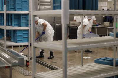 ARCHIVO - Trabajadores cumplen sus obligaciones en la cocina de un centro de detención de inmigrantes de la empresa Geo Group en Tacoma, en el estado de Washington, el 10 de septiembre de 2019 durante un recorrido para la prensa.  (AP Foto / Ted S. Warren, archivo)