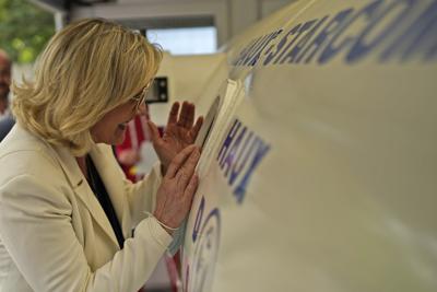 La líder de ultraderecha Marine le Pen mira a un hombre en una cámara de compresión durante una visita a una escuela de buceo en Frejus, en el sur de Francia, el jueves 17 de junio de 2021. (AP Foto/Daniel Cole)