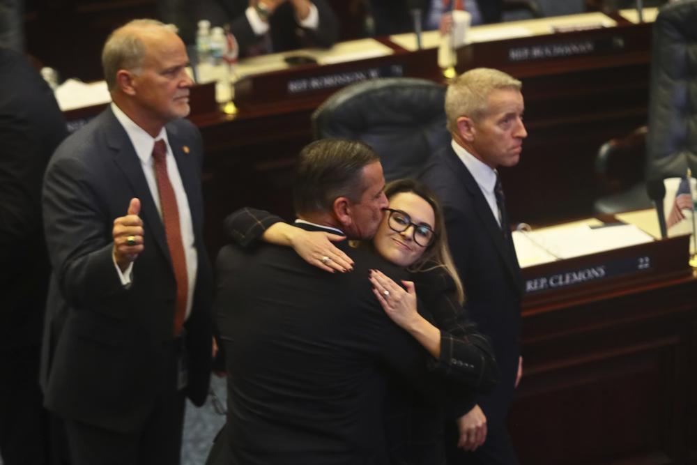 At center, Rep. Bob Rommel, R-Naples kisses Rep. Josie Tomkow, R-Polk City after his SB 2-A Property Insurance bill he co-sponsored passed 84-33 Wednesday, Dec. 14, 2022 in the House of Representatives in Tallahassee, Fla. At left is Rep. Bobby Payne, R-Palatka; at right is House Speaker Paul Renner, R-Palm Coast. Florida lawmakers are meeting to consider ways to shore up the state's struggling home insurance market in the year's second special session devoted to the topic. (AP Photo/Phil Sears)