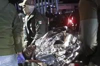 Paramedics carry a migrant who was wounded in a deadly fire at an immigration detention center in Ciudad Juarez, Mexico, Tuesday, March 28, 2023. (AP Photo/Christian Chavez)