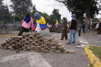 Los manifestantes construyen una barricada durante las protestas contra las políticas económicas del presidente Guillermo Lasso en el centro de Quito, Ecuador, el viernes 24 de junio de 2022. (AP Foto/Dolores Ochoa)