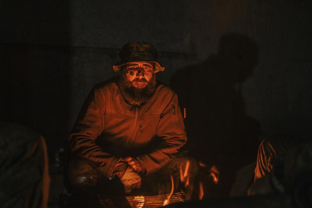 In this photo provided by Azov Special Forces Regiment of the Ukrainian National Guard Press Office, an Azov Special Forces Regiment's serviceman, injured during fighting against Russian forces, poses for a photographer inside the Azovstal steel plant in Mariupol, Ukraine, Tuesday, May 10, 2022. (Dmytro 'Orest' Kozatskyi/Azov Special Forces Regiment of the Ukrainian National Guard Press Office via AP)