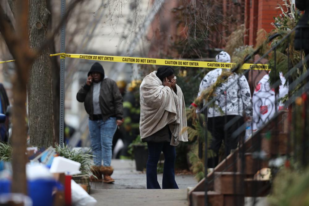 Eine nicht identifizierte Frau reagiert am Mittwoch, dem 5. Januar 2022, am Tatort eines tödlichen Reihenhausbrandes im Stadtteil Fairmount in Philadelphia. (Monica Herndon/The Philadelphia Inquirer über AP)