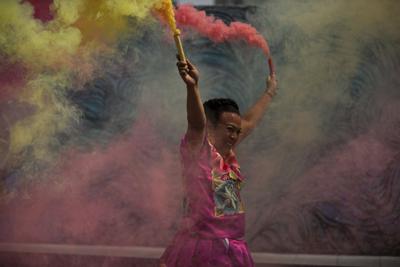 Marven, una mujer transgénero del estado de Oaxaca, lanza coloridas bengalas de humo durante su evento de campaña para un asiento en el Congreso de la Ciudad de México, afuera de un restaurante el sábado 29 de mayo de 2021.  (AP Foto/Fernando Llano)