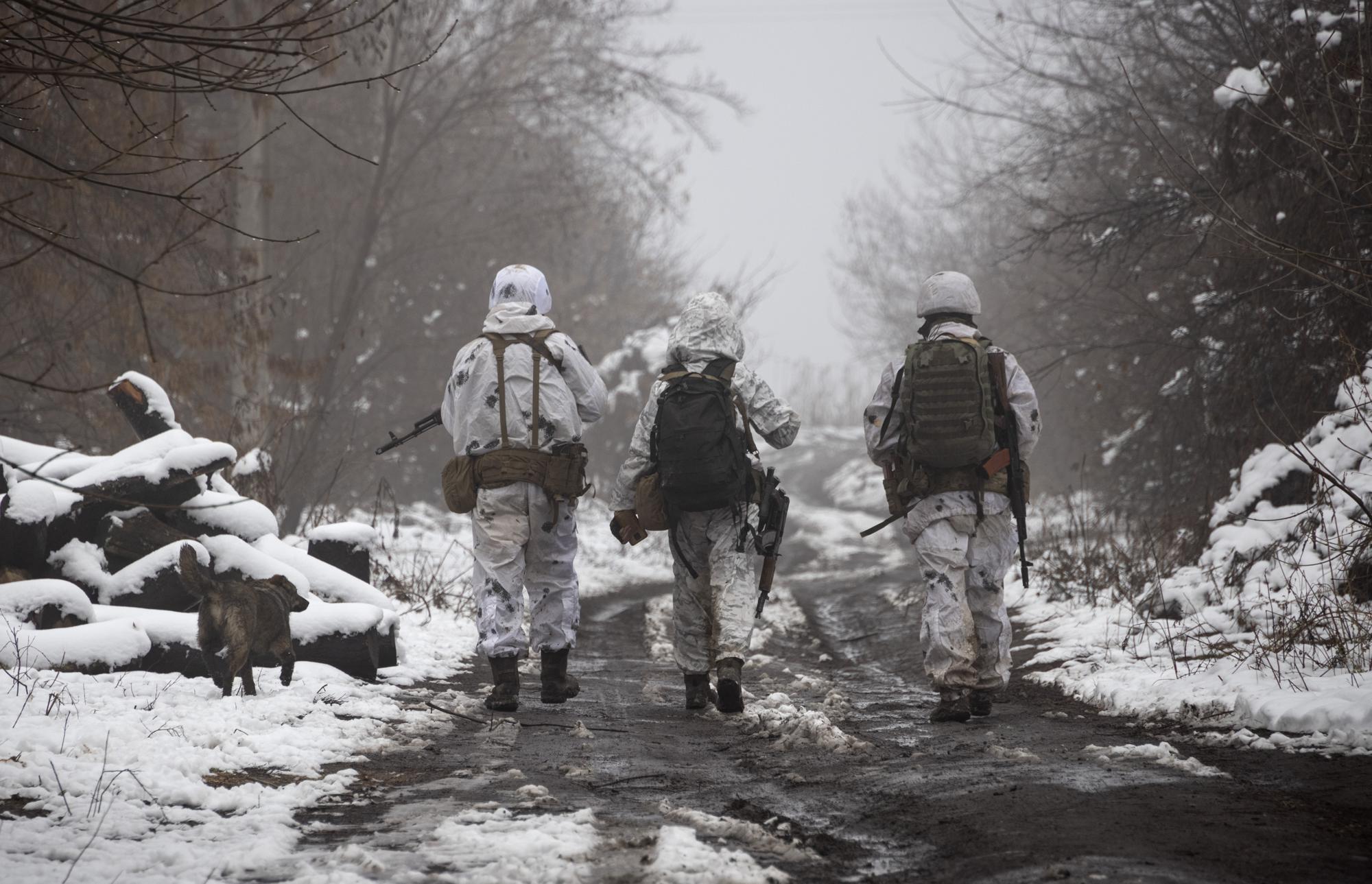 FILE - Ukrainian soldiers walk at the line of separation from pro-Russian rebels near Katerinivka, Donetsk region, Ukraine, Tuesday, Dec 7, 2021. (AP Photo/Andriy Dubchak, File)