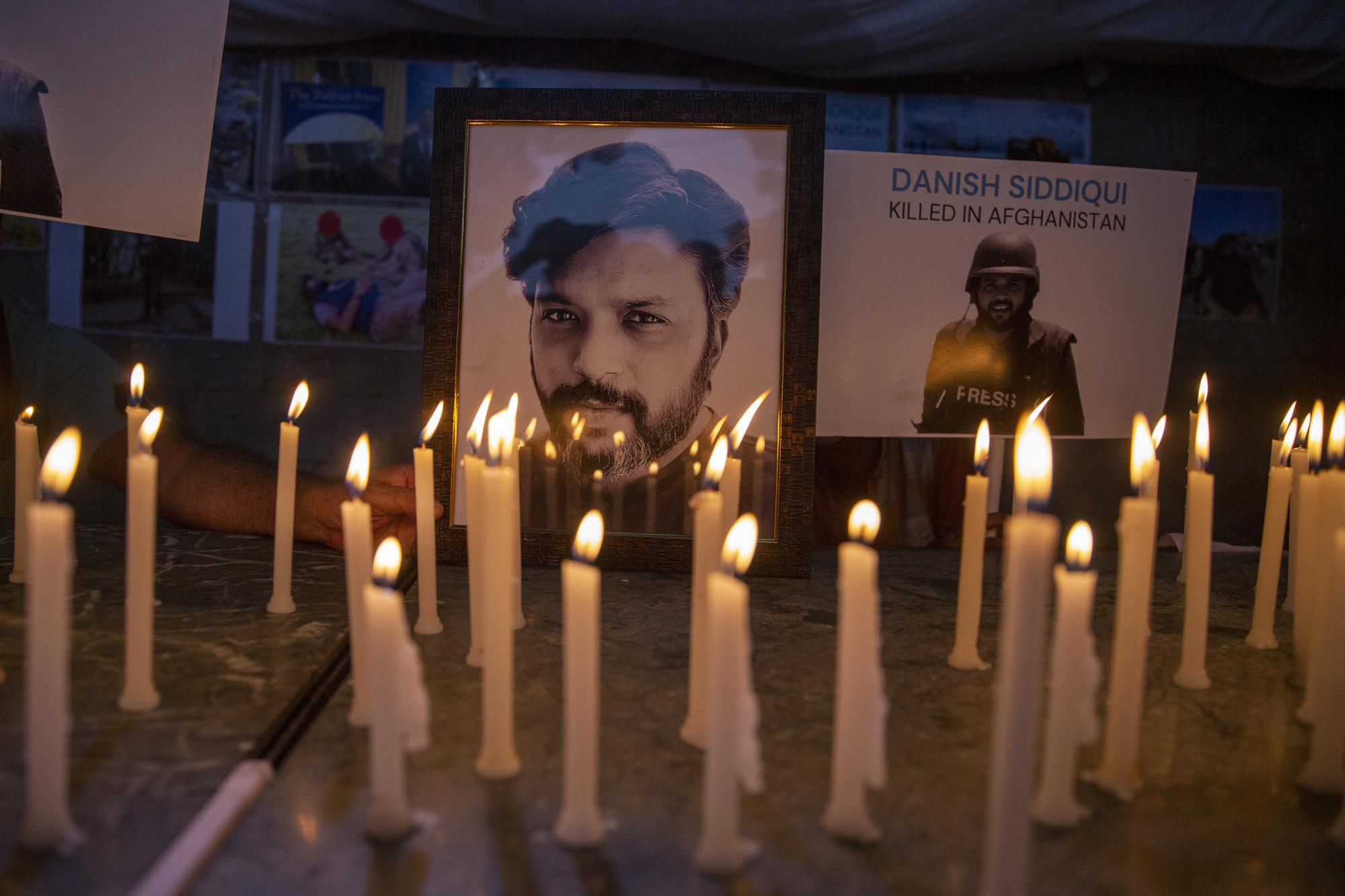 FILE - In this July 17, 2021, file photo, journalists in New Delhi, India, light candles and pay tribute to Reuters photographer Danish Siddiqui, was killed in Afghanistan covering clashes between the Taliban and Afghan security forces. (AP Photo/Altaf Qadri, File)