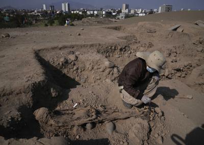 Un trabajador excava en el parque de diversiones y zoológico "Parque de las Leyendas" en Lima, Perú, el viernes 14 de octubre de 2022. Arqueólogos peruanos hallaron un cementerio colonial en una zona apartada del extenso parque y jardín botánico que es el más conocido y preferido de los niños en Lima. (Foto AP/Martín Mejía)