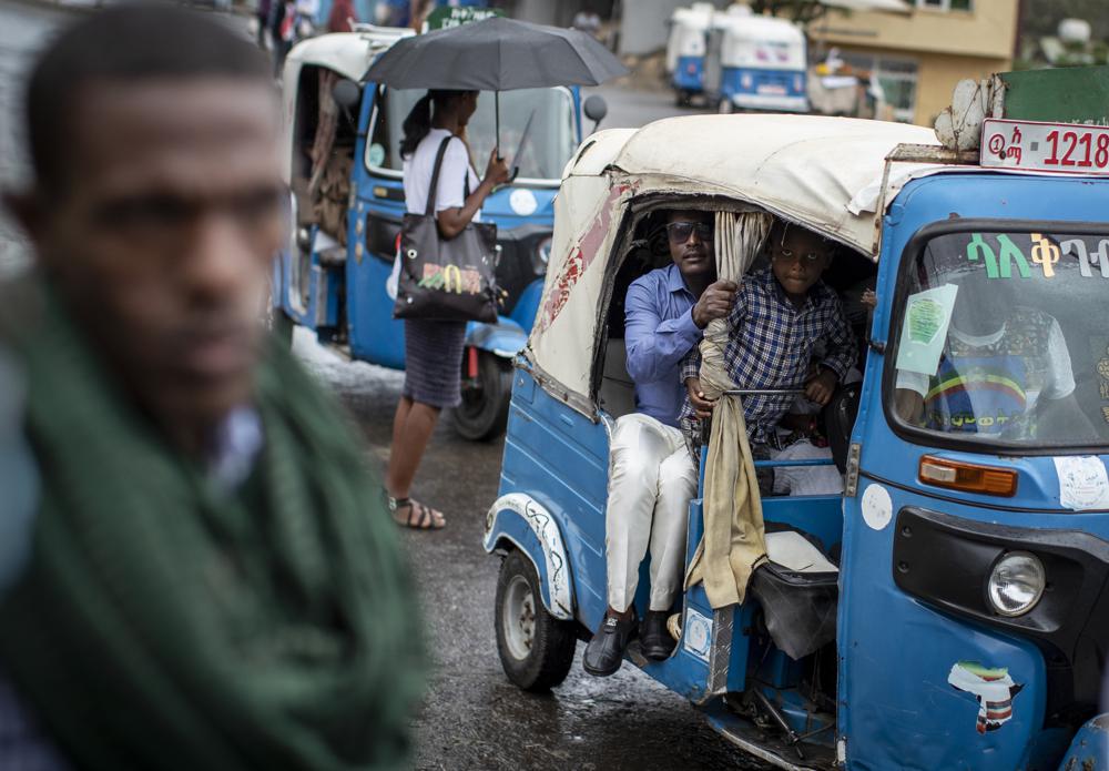 FILE - Passengers look out from an auto-rickshaw, known locally as a bajaj, in Gondar, in the Amhara region of Ethiopia on May 2, 2021. Once a key ally of the federal government in its deadly war in the Tigray region, the neighboring Amhara region has in May 2022 experienced government-led mass arrests and disappearances of activists, journalists and other perceived critics. (AP Photo/Ben Curtis, File)