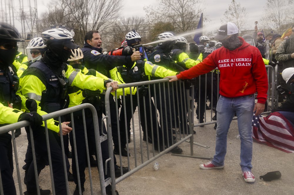 Demonstators loyal to President Donald Trump, are sprayed by police, Wednesday, Jan. 6, 2021, during a day of rioting at the Capitol. It's been a stunning day as a number of lawmakers and then the mob of protesters tried to overturn America's presidential election, undercut the nation's democracy and keep Democrat Joe Biden from replacing Trump in the White House. (AP Photo/John Minchillo)