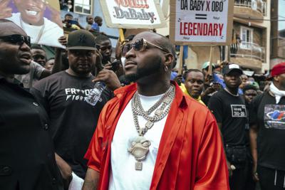 La estrella nigeriana de Afrobeats, Davido, en el centro, asiste a la filmación de un video musical en Lagos, Nigeria, el 17 de mayo de 2022. El hijo de 3 años de la estrella musical nigeriana Davido, cuyo verdadero nombre es David Adeleke, murió en su casa en un aparente ahogamiento, dijo la policía el martes 1 de noviembre de 2022. Adeleke, no estaba en la casa en el momento de la muerte de Ifeanyi el lunes por la noche. La madre del niño, Chioma Rowland, también estaba ausente, según el portavoz de la policía de Lagos, Ben Hundeyin. (AP Photo/Grace Ekpu)