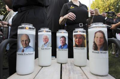 Fotografía de archivo del 29 de junio de 2018 de veladoras con fotos de cinco empleados del periódico Capital Gazette durante una vigilia frente a la redacción en donde fueron asesinados en Annapolis, Maryland. (AP Foto/Jose Luis Magana, Archivo)