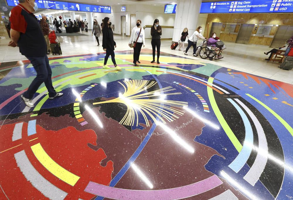Los viajeros caminan por la Terminal A en el Aeropuerto Internacional de Orlando el día de Navidad, sábado 25 de diciembre de 2021, en Orlando, Florida (Stephen M. Dowell / Orlando Sentinel vía AP)
