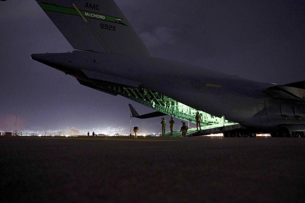 FILE - In this Aug. 30, 2021 photo provided by the U.S. Air Force, an Air Force aircrew, assigned to the 816th Expeditionary Airlift Squadron, prepares to receive soldiers, assigned to the 82nd Airborne Division, to board a U.S. Air Force C-17 Globemaster III aircraft in support of the final noncombatant evacuation operation missions at Hamid Karzai International Airport in Kabul Afghanistan. The Taliban, which is in need of foreign aid, has said it will allow people with valid travel papers to leave, and the international community says it will be monitoring to see if they keep their word. (Senior Airman Taylor Crul/U.S. Air Force via AP)