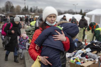 Una mujer que huyó de Ucrania carga a su hijo a su llegada al cruce fronterizo de Medyka, el lunes 28 de febrero de 2022, en Polonia. (AP Foto/Visar Kryeziu)