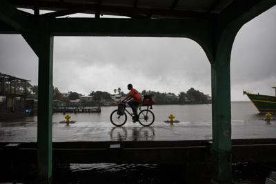 Un hombre monta bicicleta bajo la lluvia que acompaña a la tormenta tropical Bonnie en Bluefields, Nicaragua, el viernes 1 de julio de 2022. (AP Foto/Inti Ocon)