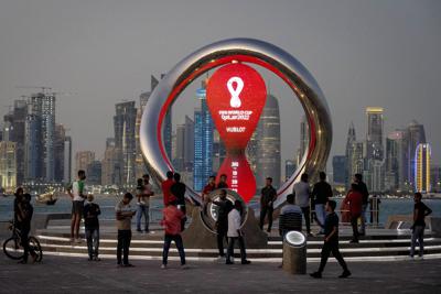 ARCHIVO - La gente se reúne alrededor del reloj de cuenta regresiva oficial que muestra el tiempo restante hasta el inicio de la Copa Mundial 2022, en Doha, Qatar, el jueves 25 de noviembre de 2021. Qatar será el anfitrión de la Copa Mundial de la FIFA 2022, pero el fútbol no es el único deporte que se juega en el país del Golfo Pérsico. Desde actividades tradicionales hasta competiciones mundiales, Qatar se ha comercializado cada vez más como anfitrión de deportes de todo tipo. (AP Photo/Darko Bandic, archivo)