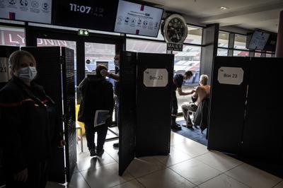 ARCHIVO - En esta imagen de archivo del sábado 3 de abril de 2021, pacientes reciben una inyección de la vacuna de Moderna contra el COVID-19 en el primer día de vacunaciones masivas en el estadio del  club de fútbol Olympique Lyonnais en Decines-Charpieu, Francia. (Jean-Philippe Ksiazek, ARCHIVO Pool via AP)
