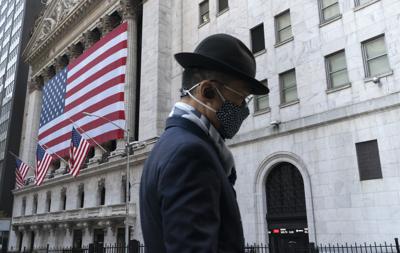 En esta imagen del 16 de noviembre de 2020, un hombre con mascarilla pasa frente a la Bolsa de Valores de Nueva York. (AP Foto/Mark Lennihan, Archivo)