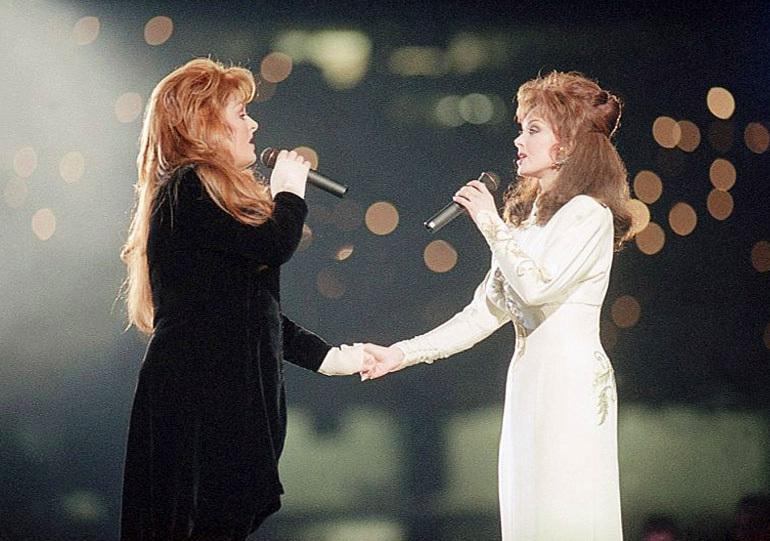 FILE - Wynonna Judd, left, and her mother Naomi Judd, of The Judds, perform during the halftime show at Super Bowl XXVIII in Atlanta on Jan. 30, 1994. The Grammy-winning duo will be inducted into the Country Music Hall of Fame.  (AP Photo/Eric Draper, File)