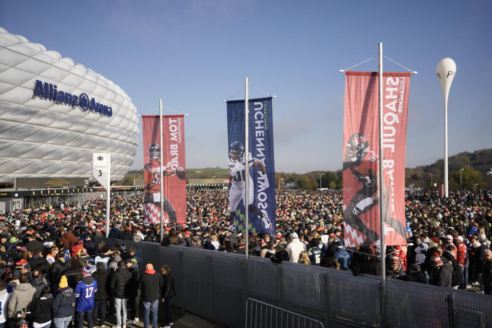 A crowd of fans arrive for a NFL match between Tampa Bay Buccaneers and Seattle Seahawks at the Allianz Arena in Munich, Germany, Sunday, Nov. 13, 2022. (AP Photo/Markus Schreiber)