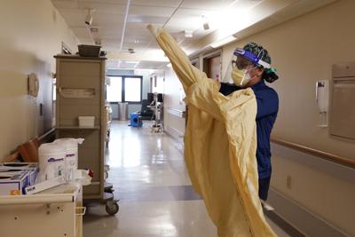 ARCHIVO  - La enfermera Monica Quintana se pone trajes de protección antes de ingresar a una sala del hospital William Beaumont, el 21 de abril de 2021 en Royal Oak, Michigan. (AP Foto/Carlos Osorio, archivo)