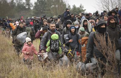 Migrantes avanzan hacia el puesto de revisión "Kuznitsa" en la frontera entre Bielorrusia y Polonia cerca de Grodno, Bielorrusia, el lunes 15 de noviembre de 2021. (Oksana Manchuk/BelTA pool photo via AP)