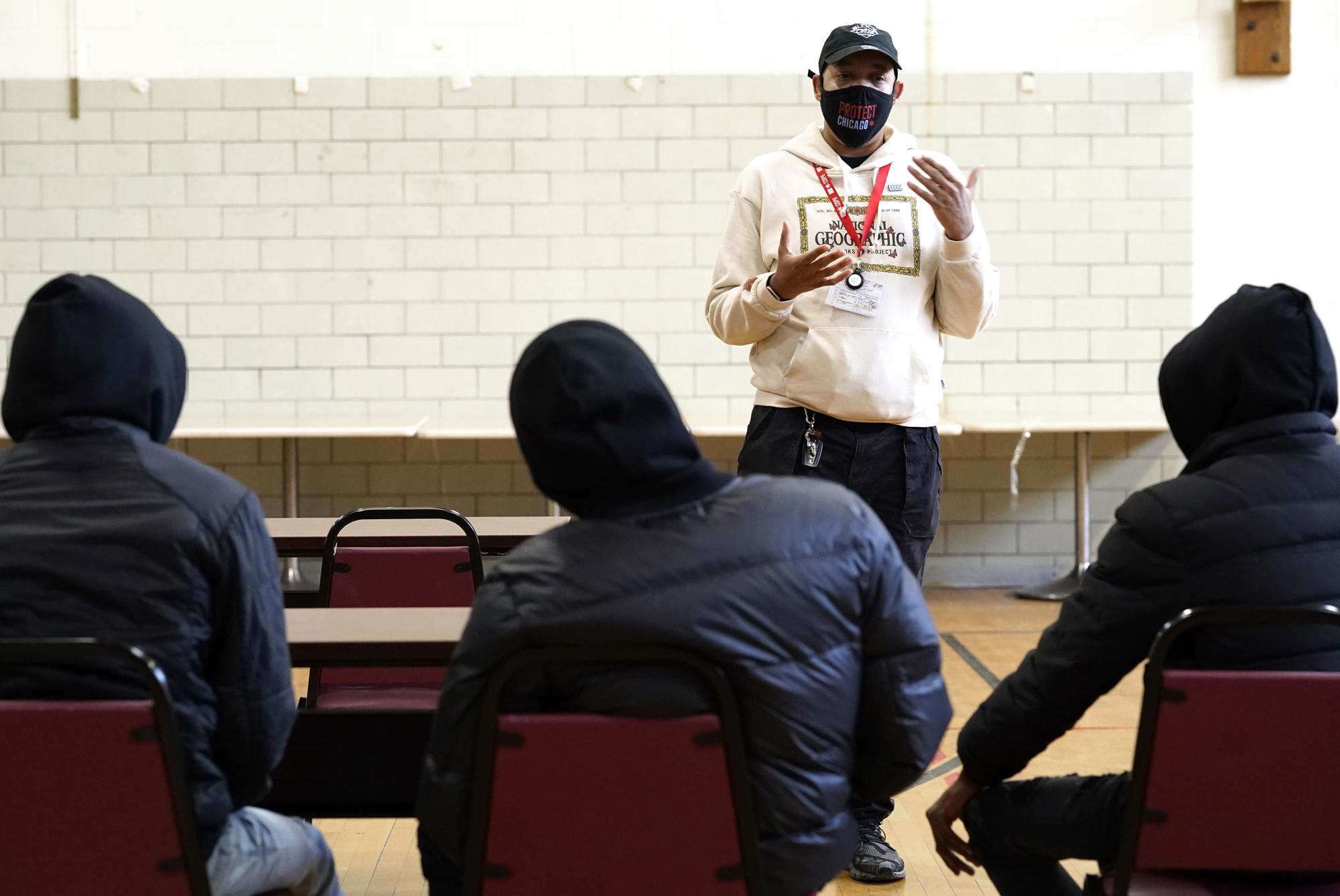 Caesar Thompson talks to participants in the Rapid Employment and Development Initiative, READI Chicago program, during Thompson's Q&A session on the COVID-19 vaccines Tuesday, Dec. 14, 2021, in Chicago. Thompson has spent the past several months in Chicago communities hard-hit by COVID-19, working with city public health authorities to boost vaccination rates. (AP Photo/Charles Rex Arbogast)