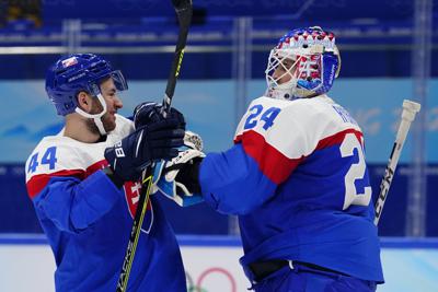 Slovakia's Mislav Rosandic (44) congratulates goalkeeper Patrik Rybar (24) after a 4-0 win against Germany a men's qualification round hockey game at the 2022 Winter Olympics, Tuesday, Feb. 15, 2022, in Beijing. (AP Photo/Matt Slocum)